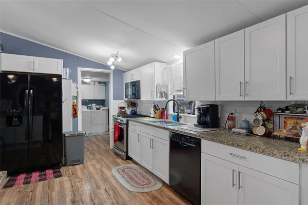 a kitchen with refrigerator and cabinets
