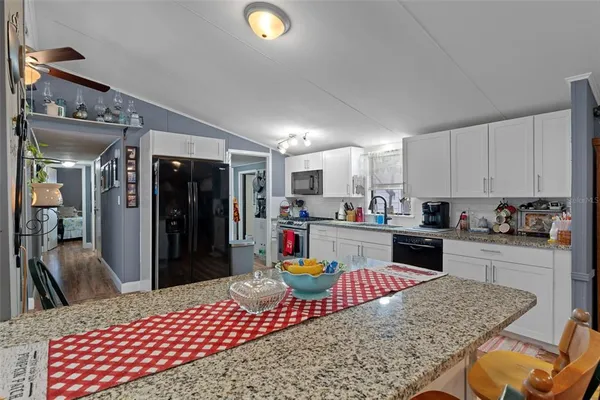 a kitchen with stainless steel appliances granite countertop a refrigerator sink and stove