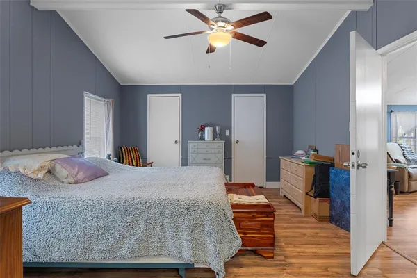 a bedroom with a bed and wooden floor