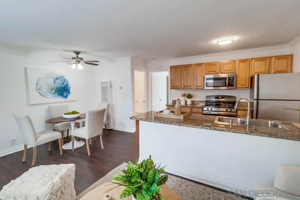 4375 Felton Street, Unit 3 San Diego, CA 92104 - Photo 5 of 27 a kitchen with stainless steel appliances granite countertop a refrigerator a stove a sink a dining table and chairs with wooden floor