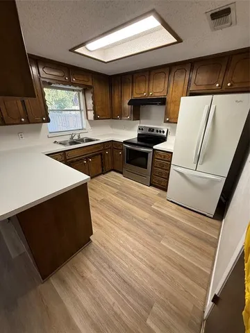 a kitchen with stainless steel appliances a refrigerator sink and stove