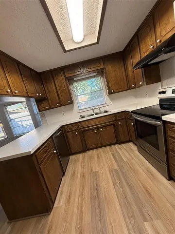 a kitchen with stainless steel appliances wooden cabinets and a stove top oven
