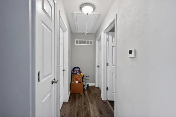 a view of a hallway with wooden floor and closet