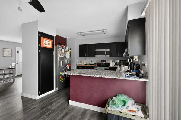 a kitchen with stainless steel appliances granite countertop a refrigerator a stove top oven a sink and dishwasher