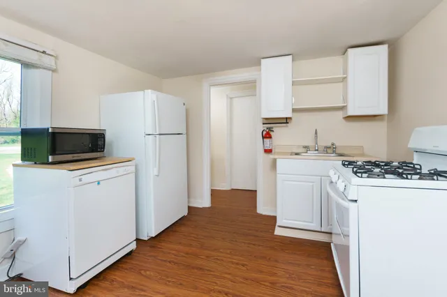 a kitchen with a refrigerator stove and white cabinets