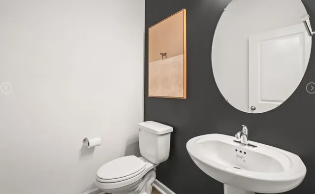 a bathroom with a toilet a sink and mirror