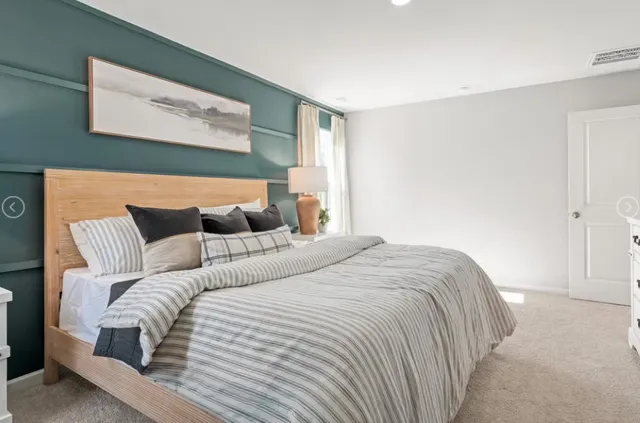 a bedroom with a large bed and a night stand