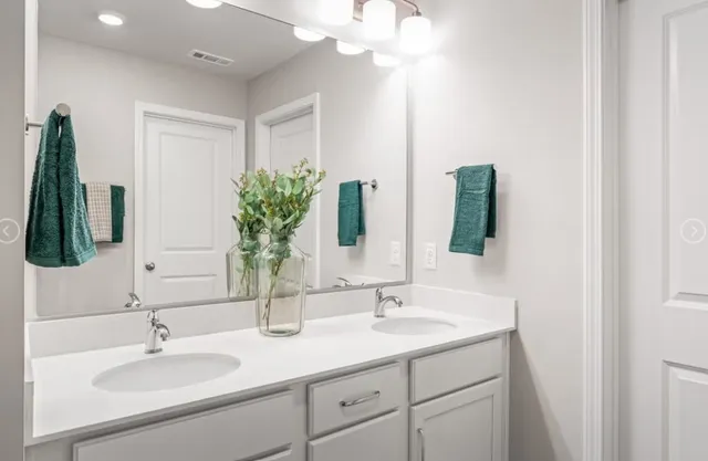 a bathroom with a double vanity sink and a mirror