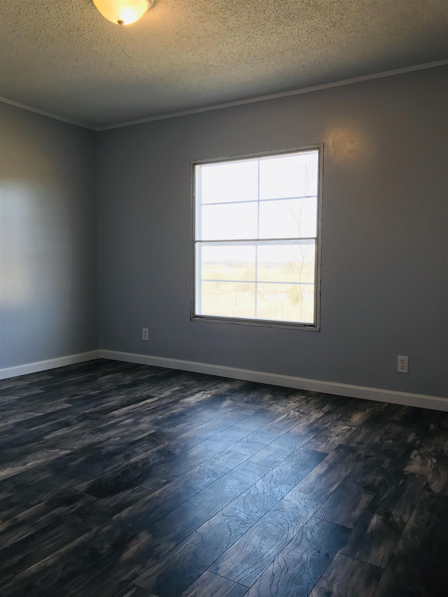 145 Absher Road Portland, TN 37148 - Photo 14 of 22 an empty room with wooden floor and windows