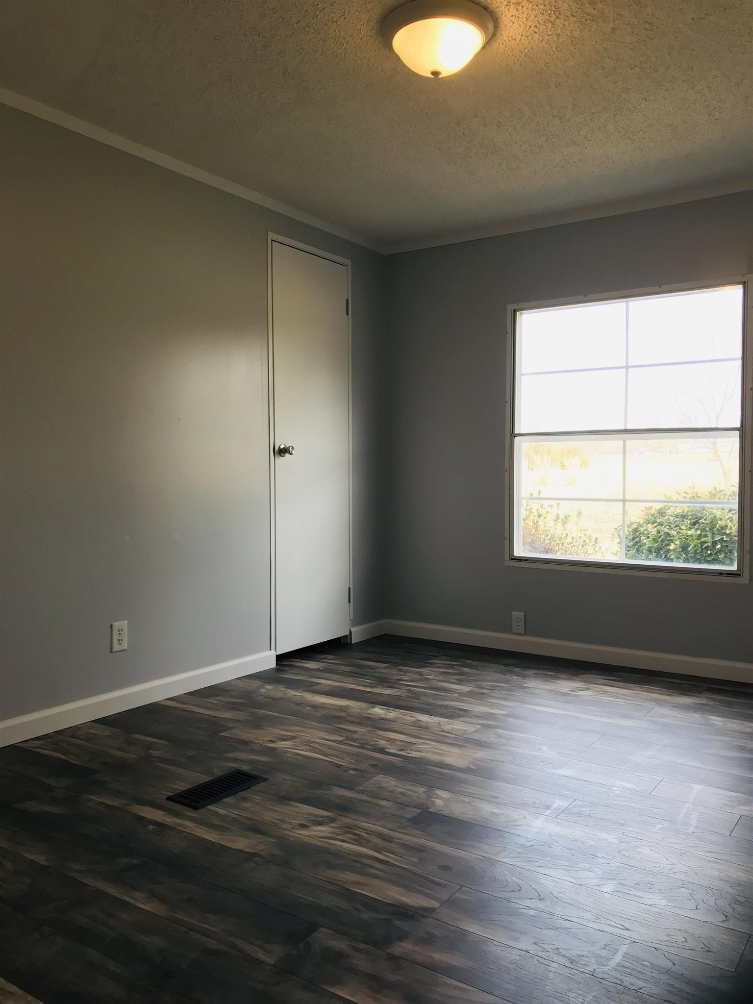 145 Absher Road Portland, TN 37148 - Photo 16 of 22 a view of an empty room with wooden floor and a window