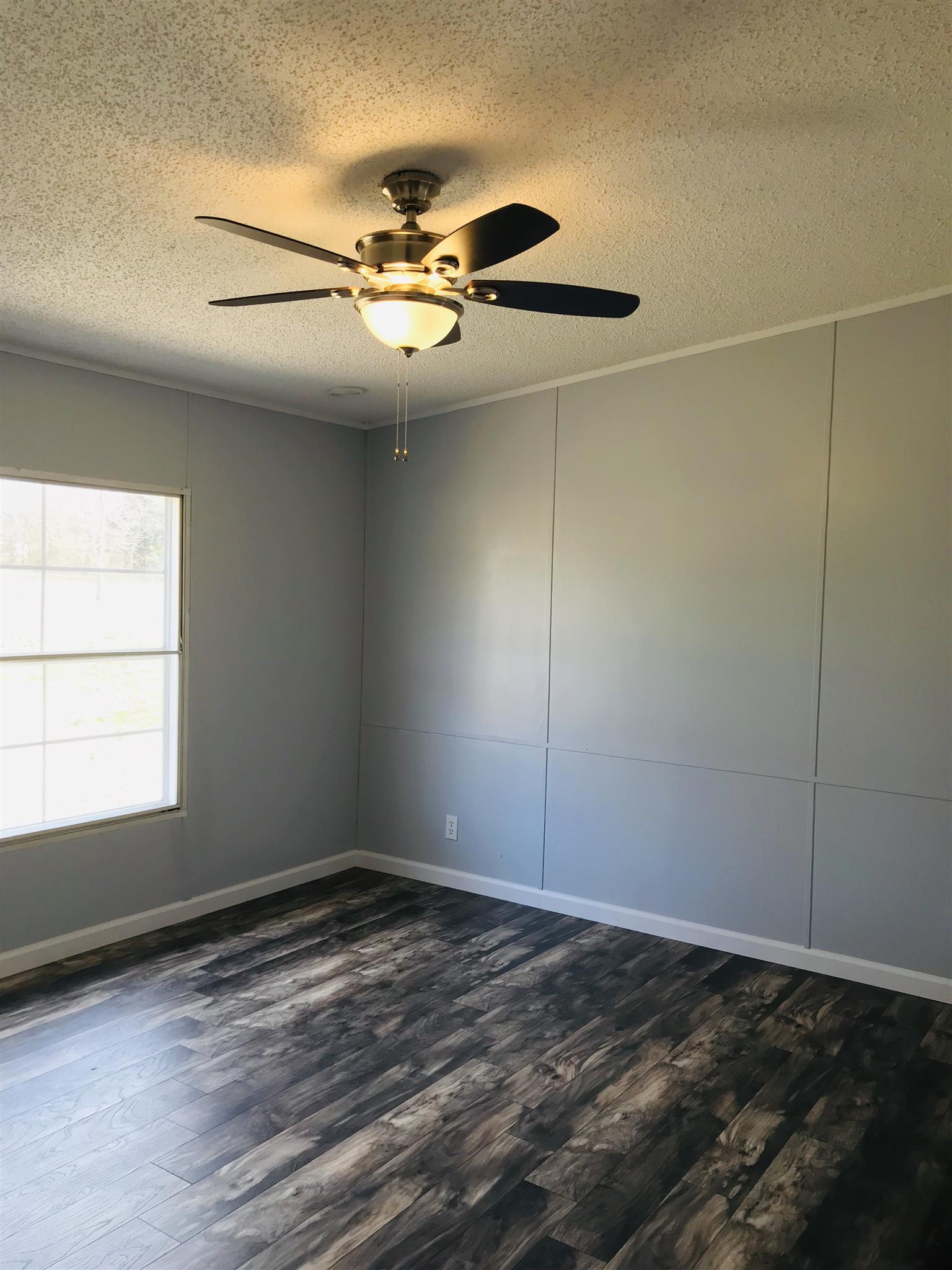 145 Absher Road Portland, TN 37148 - Photo 7 of 22 a view of an empty room with wooden floor and a window