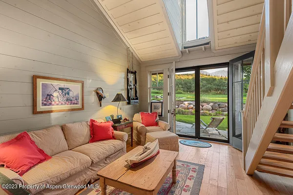 a living room with furniture and a large window with garden view