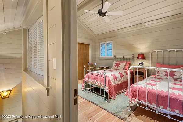 a bed room with two beds and a ceiling fan