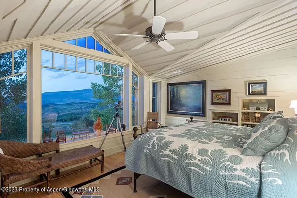 a bedroom with a bed and glass walk in closet