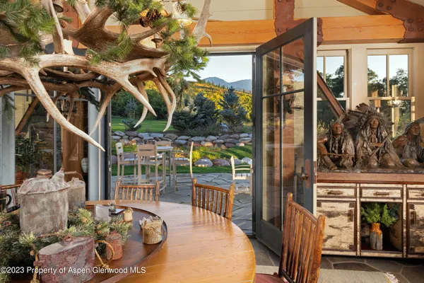 a view of a chairs and table in patio with a barbeque grill
