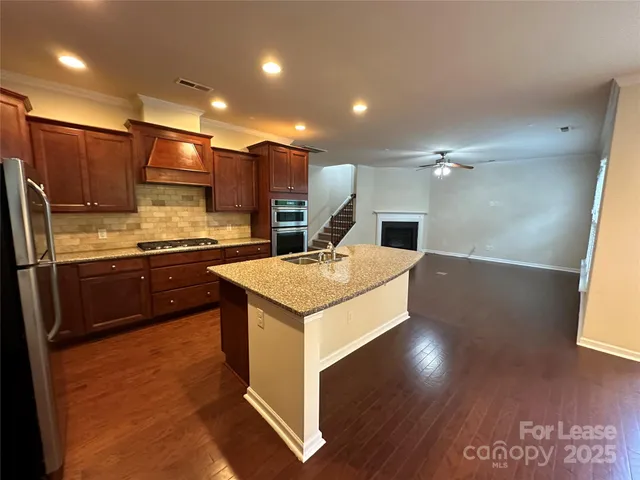 a kitchen with kitchen island granite countertop a sink and a granite counter tops