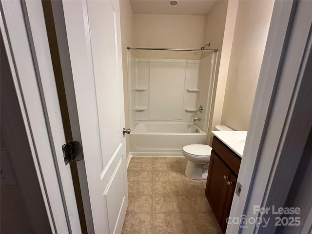 a bathroom with a granite countertop shower and a toilet