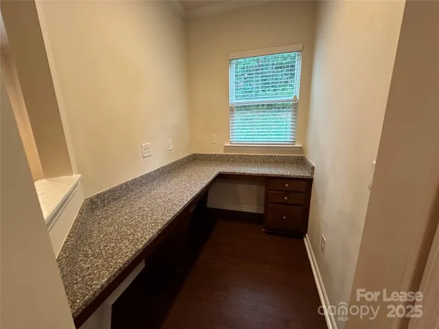 a view of a livingroom with wooden floor and a ceiling fan