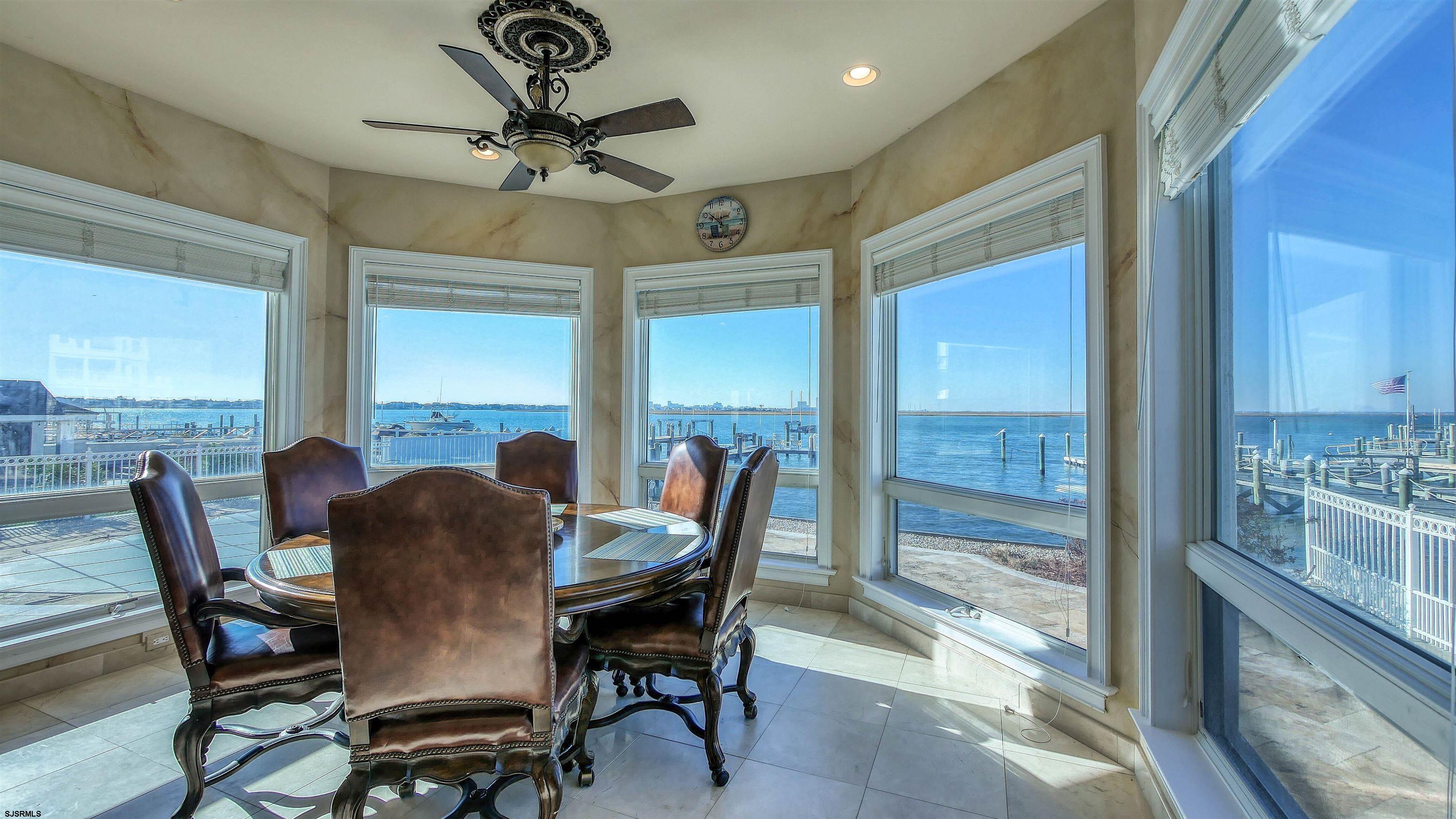 530 West Shore Drive, Unit DIRECT BAYFRONT Brigantine, NJ 08203 - Photo 11 of 63 a dining room with furniture a chandelier and a rug