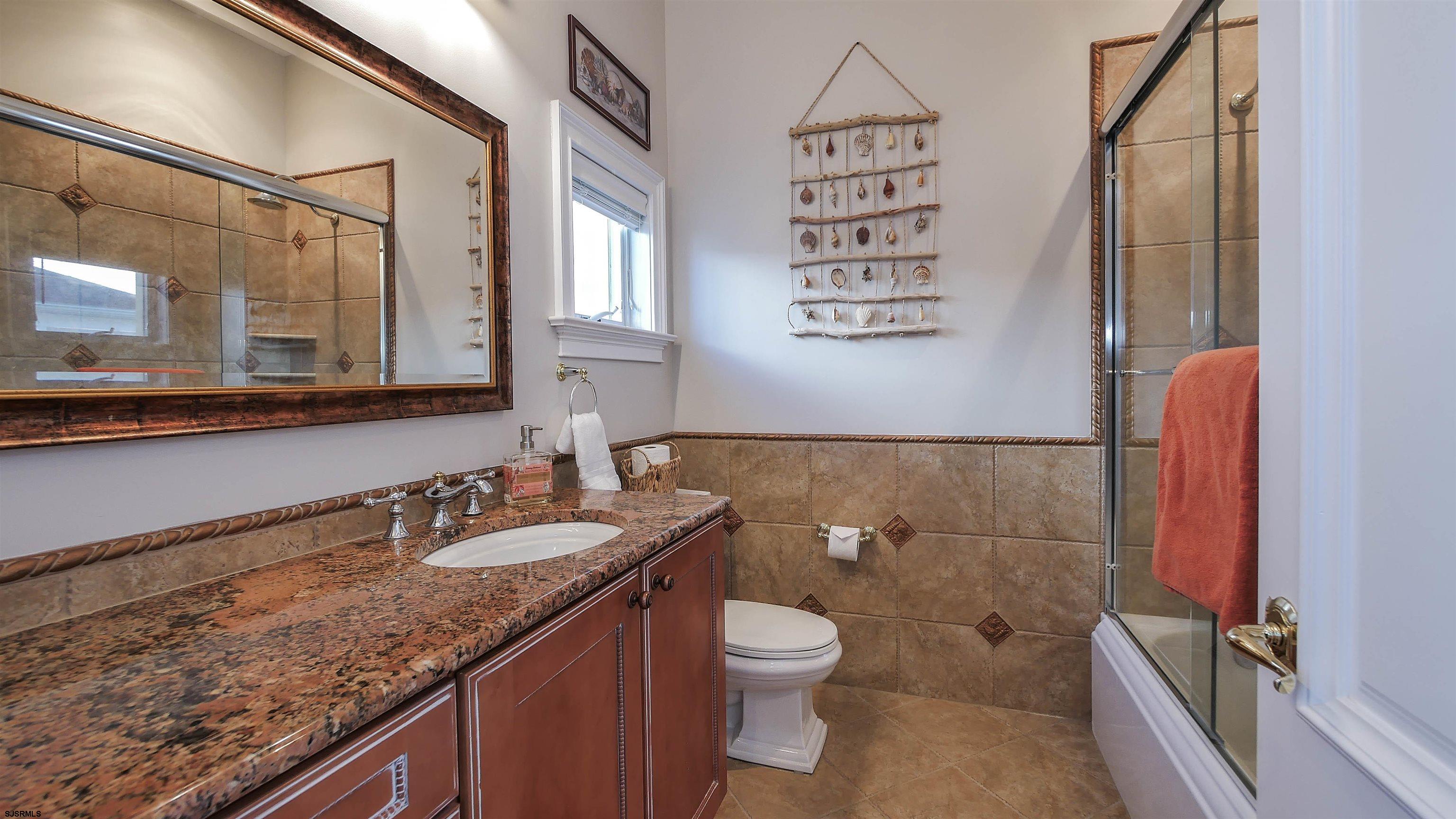 530 West Shore Drive, Unit DIRECT BAYFRONT Brigantine, NJ 08203 - Photo 21 of 63 a bathroom with a granite countertop sink a toilet and a mirror