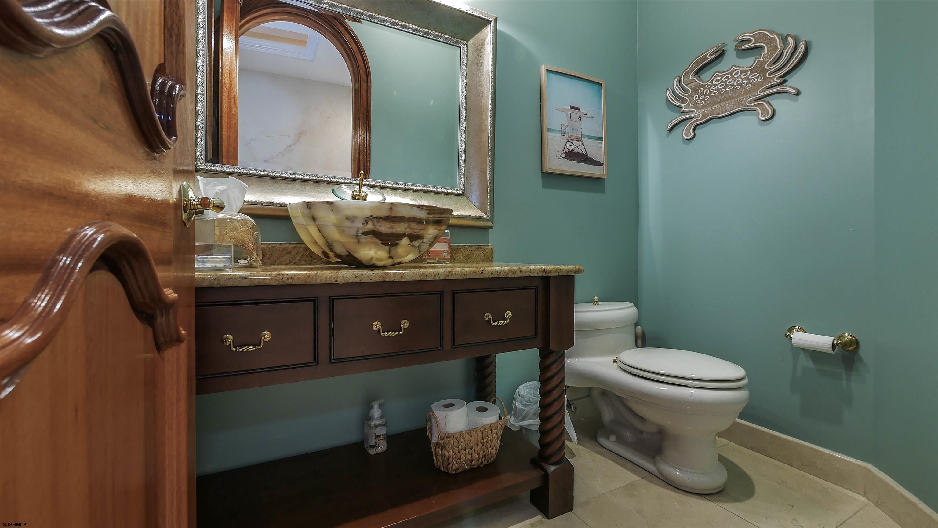 530 West Shore Drive, Unit DIRECT BAYFRONT Brigantine, NJ 08203 - Photo 22 of 63 a bathroom with a toilet sink and mirror