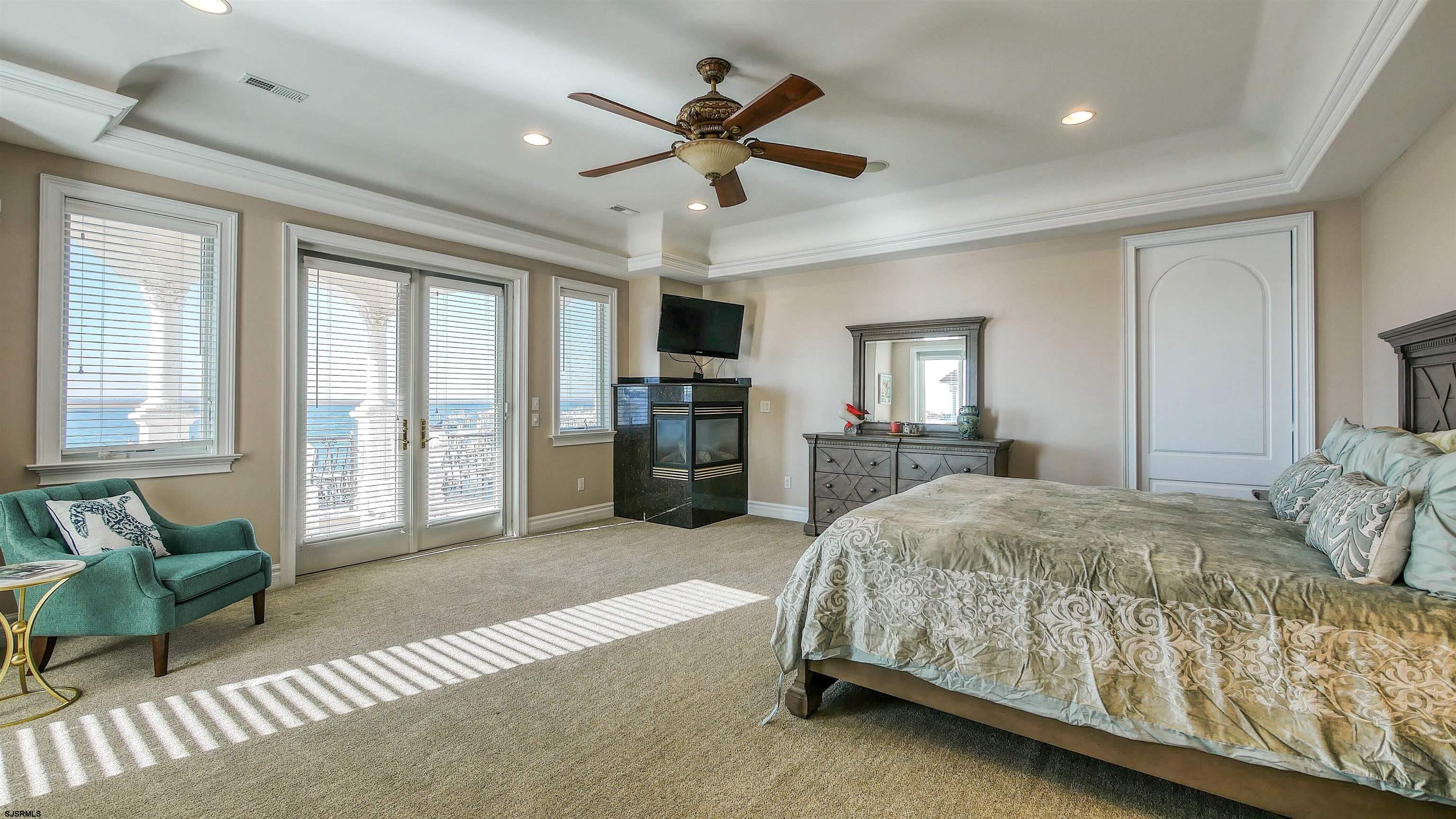 530 West Shore Drive, Unit DIRECT BAYFRONT Brigantine, NJ 08203 - Photo 41 of 63 a spacious bedroom with a bed and ceiling fan