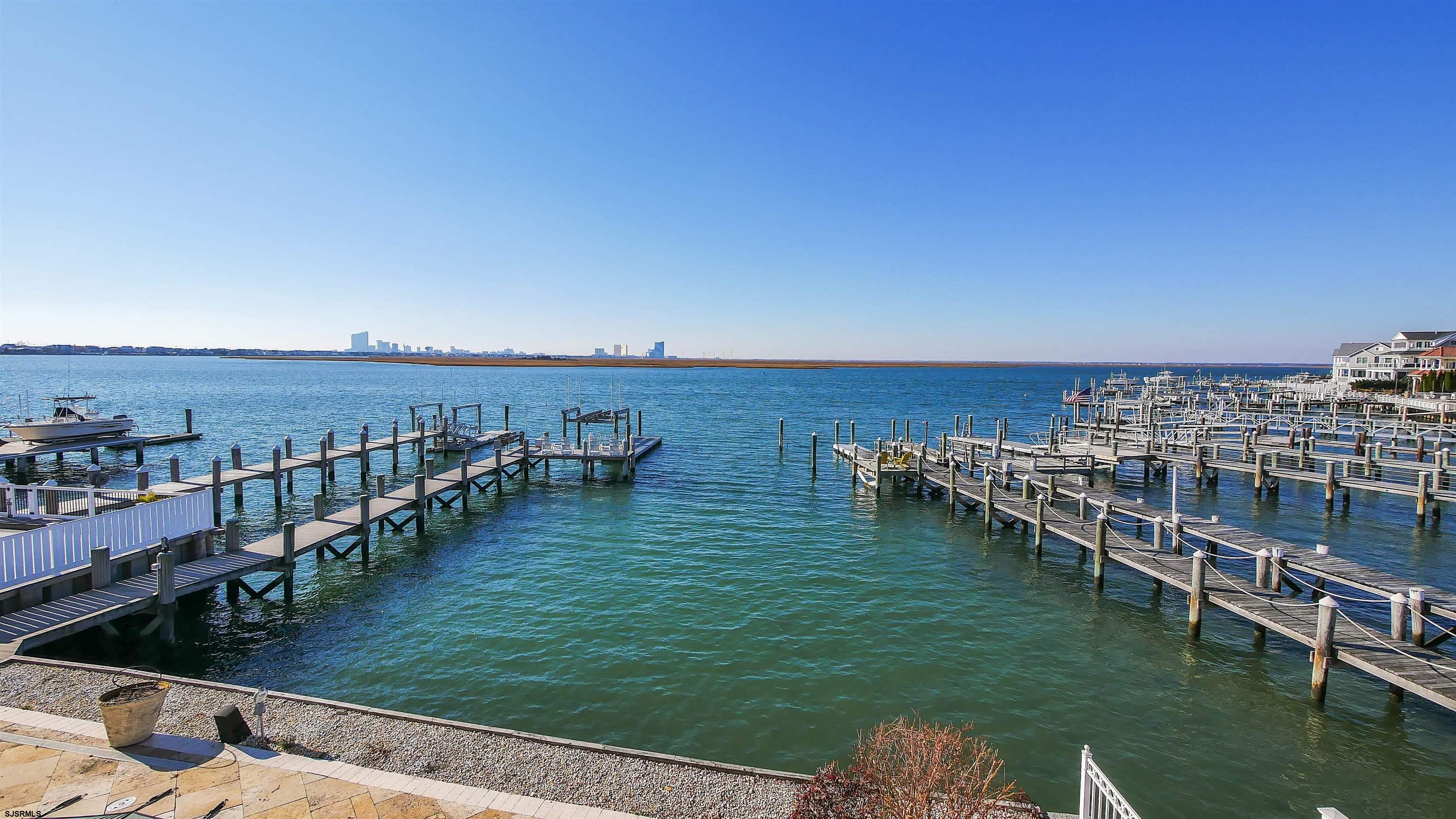 530 West Shore Drive, Unit DIRECT BAYFRONT Brigantine, NJ 08203 - Photo 45 of 63 a view of a lake with lawn chairs