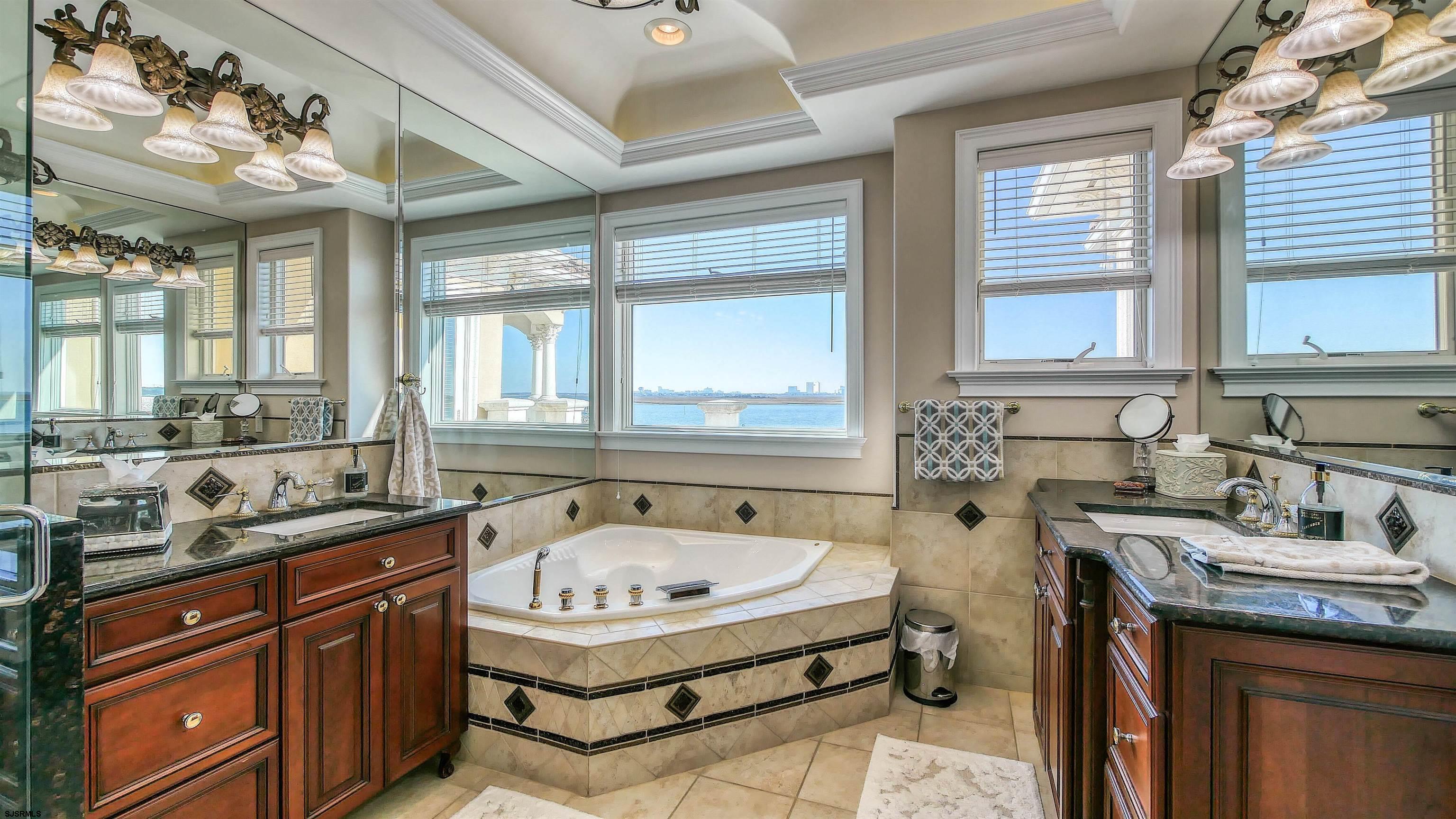 530 West Shore Drive, Unit DIRECT BAYFRONT Brigantine, NJ 08203 - Photo 50 of 63 a bathroom with a granite countertop sink a large mirror and a bathtub next to a window