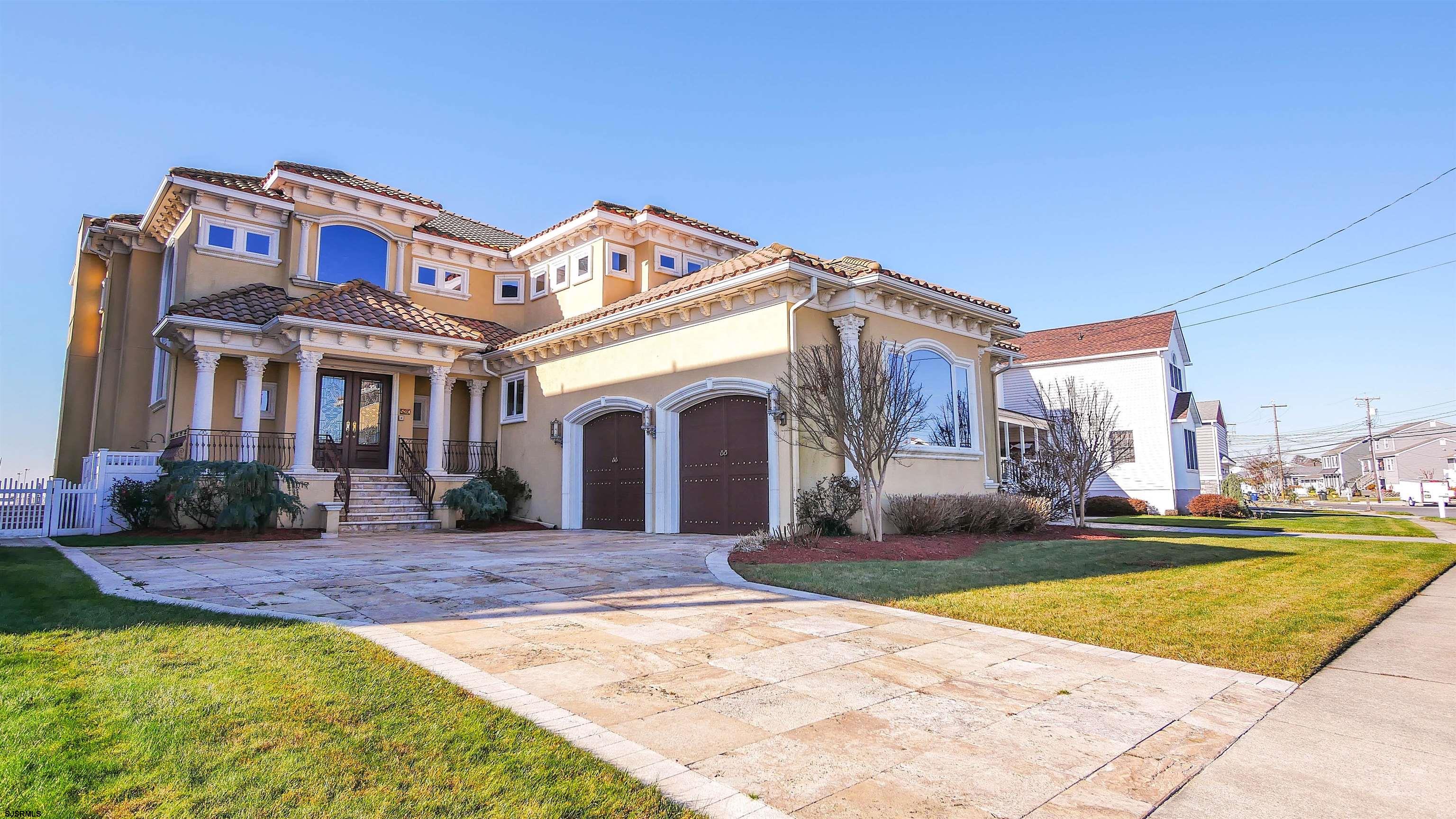 530 West Shore Drive, Unit DIRECT BAYFRONT Brigantine, NJ 08203 - Photo 63 of 63 a front view of a house with a yard table and chairs