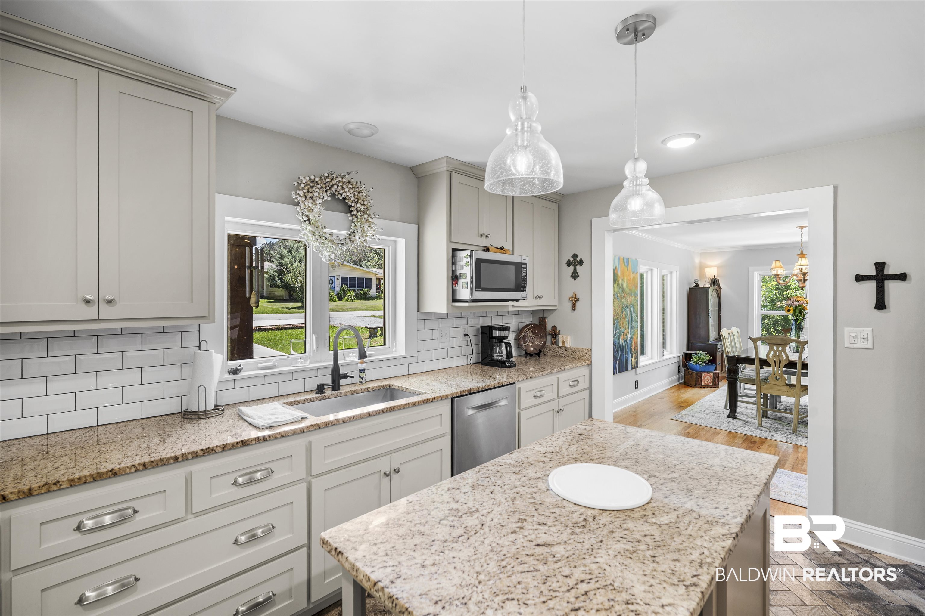 1615 5th Street Daphne, AL 36526 - Photo 9 of 28 Kitchen featuring light cabinetry with brushed nickel hardware, granite countertops, white subway tile backsplash, and a stainless steel dishwasher