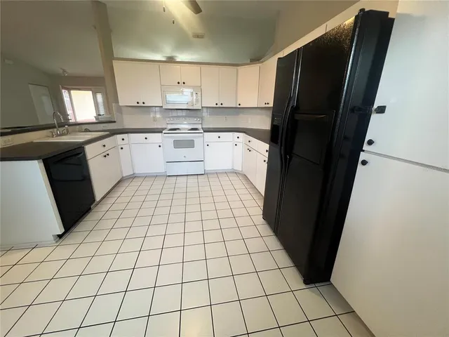 a kitchen with a sink a refrigerator and cabinets