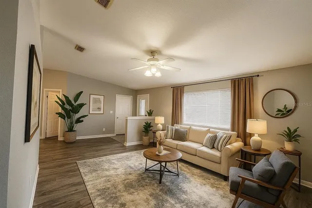 a living room with furniture ceiling fan and a rug
