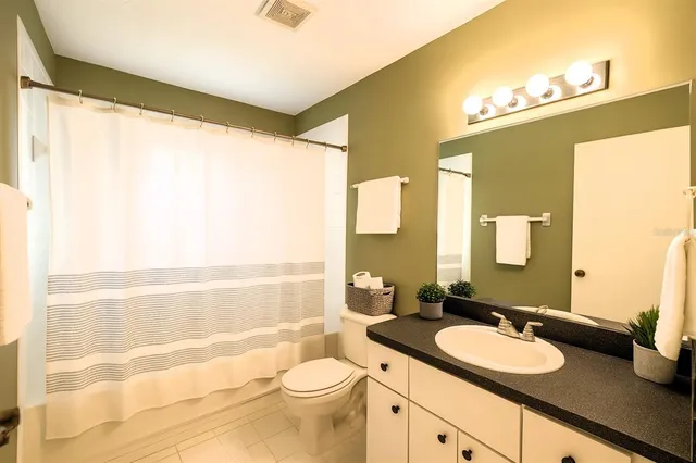 a bathroom with a double vanity sink toilet mirror and shower