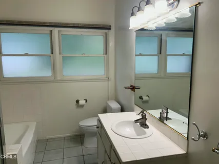 a bathroom with a sink toilet and a mirror
