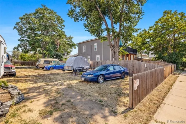 a view of a street with cars parked in front of it