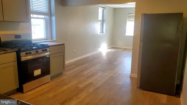 a kitchen with granite countertop a stove top oven sink and cabinets