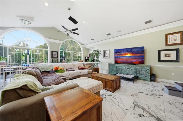 a living room with furniture a chandelier and a flat screen tv