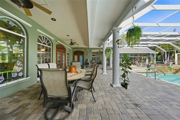 a view of a swimming pool with a table and chairs under an umbrella