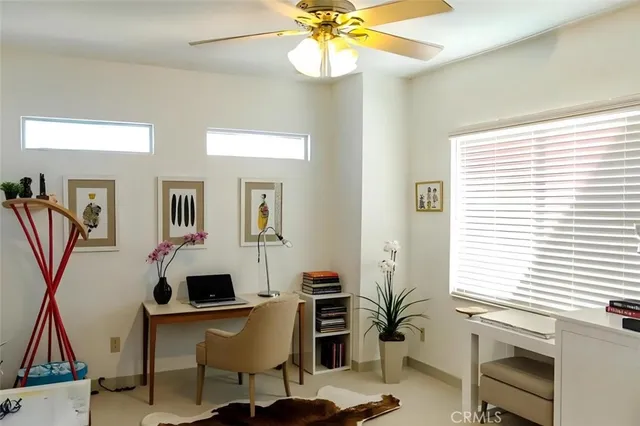 a view of a workspace with furniture and a window