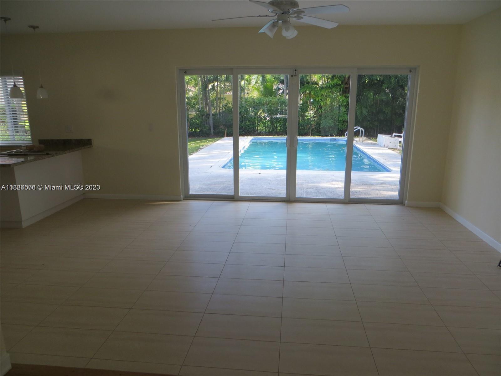 Granada Coral Gables, FL 33134 - Photo 3 of 13 an empty room with a floor to ceiling window and an outdoor view