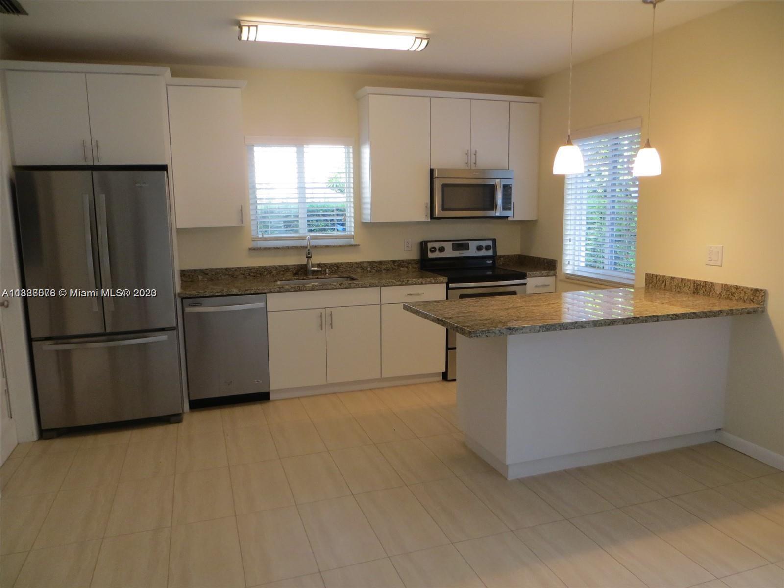 Granada Coral Gables, FL 33134 - Photo 5 of 13 a kitchen with stainless steel appliances granite countertop a stove a sink and a refrigerator
