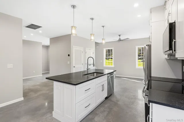 an open kitchen with a sink a stove and a refrigerator
