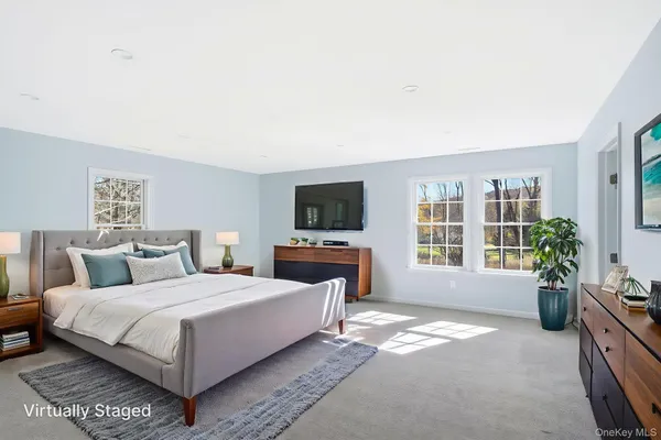 a bedroom with a large bed and a potted plant