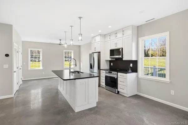 an open kitchen with a sink a stove and a refrigerator