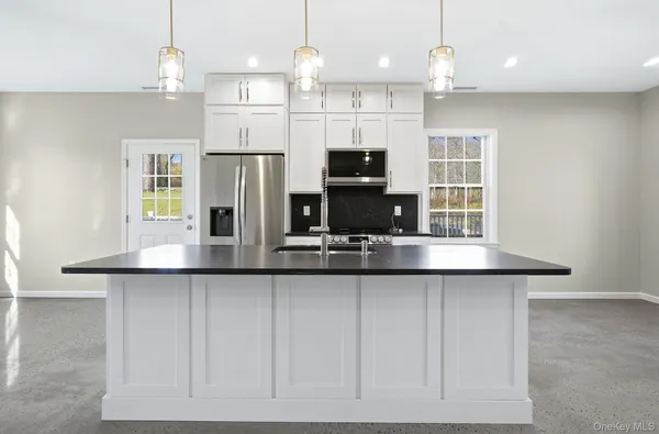 a kitchen with stainless steel appliances granite countertop a sink a stove and a refrigerator