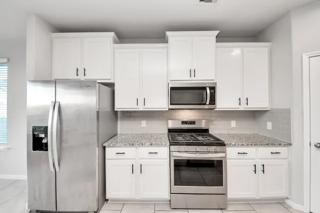 a kitchen with cabinets stainless steel appliances and a counter space