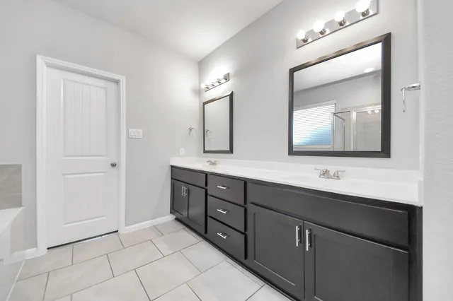 a bathroom with a double vanity sink and a mirror