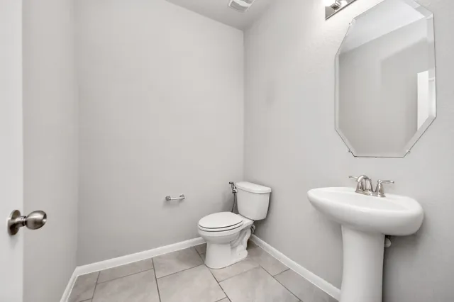 a bathroom with a sink toilet and a mirror