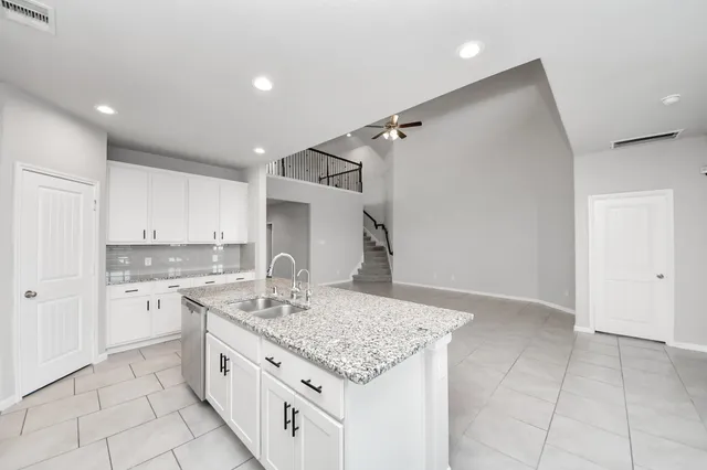 a kitchen with granite countertop a sink stove and cabinets