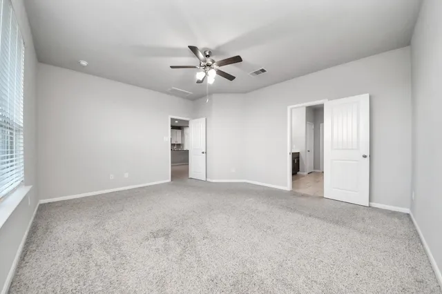 an empty room with fan and windows